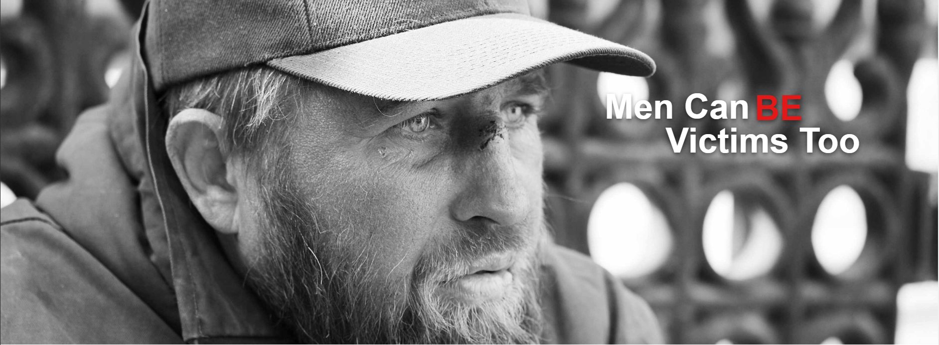 A man looking into the distance. Caption: Men can be victims too.